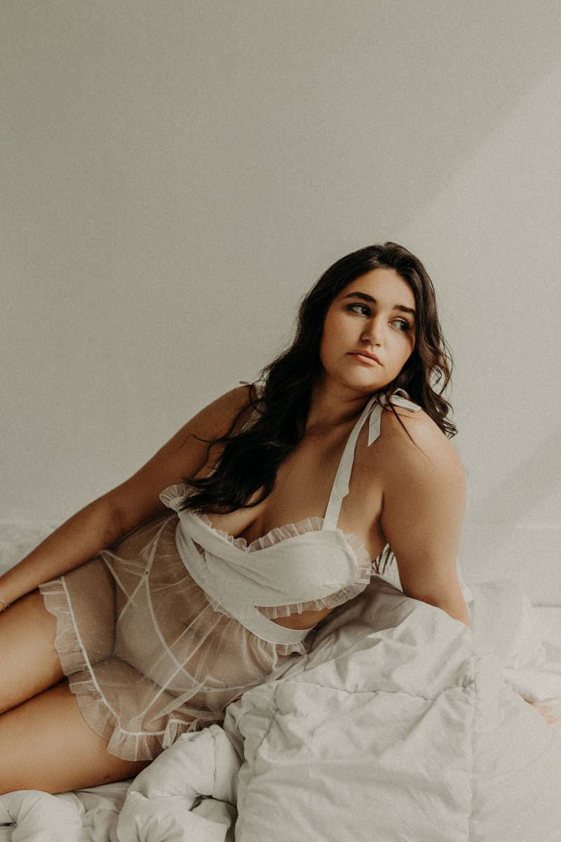 A brunette woman in all white lingerie in Tonya Rock's Ames Studio.